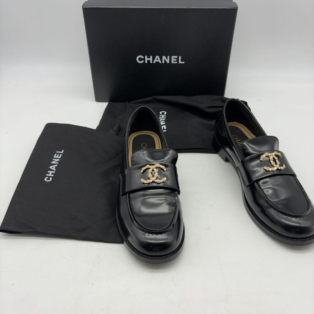 CHANEL Black Leather Women Loafers with Gold CC Emblem.
